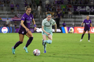 Orlando's Coriana Dyke runs with the ball past Gotham's Rose Lavelle