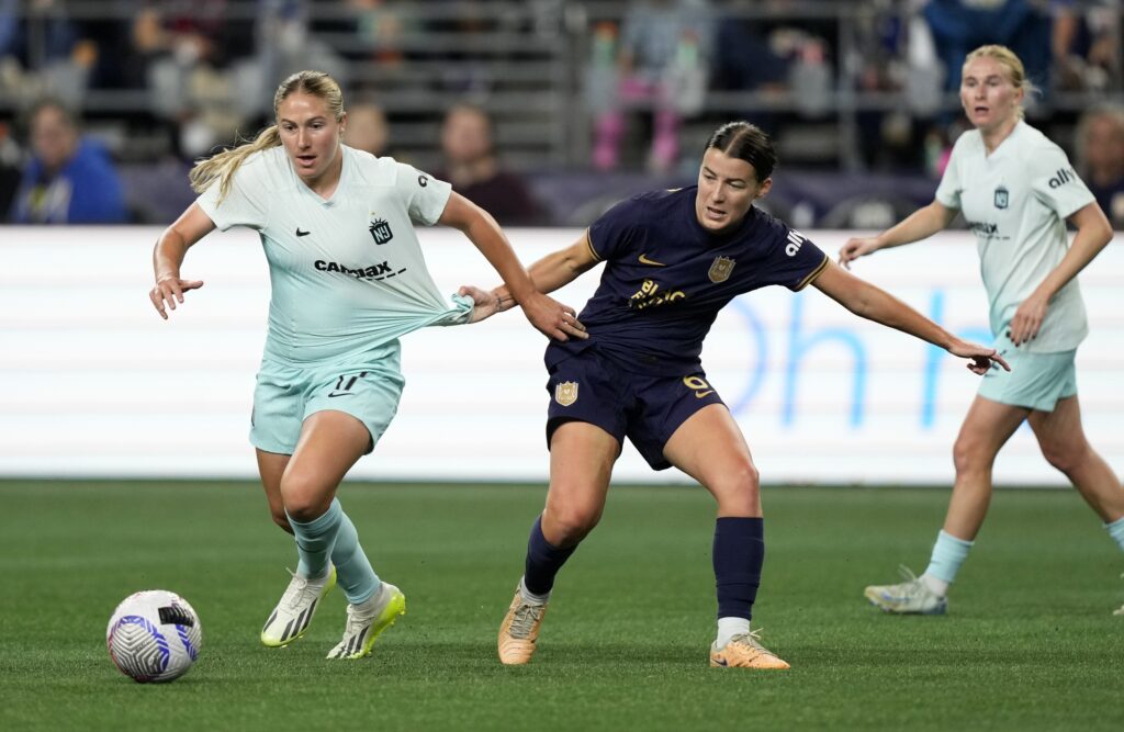 Gotham midfielder Delanie Sheehan dribbles past Seattle midfielder Angharad James.