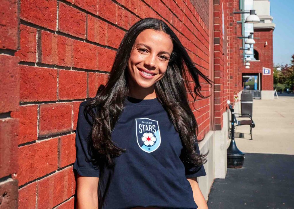 Mal Swanson of the Chicago Red Stars models the team's new logo on a t-shirt.