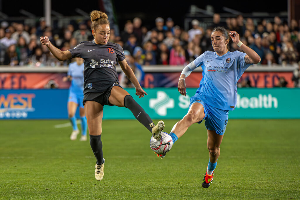 Bay's Savannah King and Houston's Diana Ordóñez battle for the ball during an NWSL match.