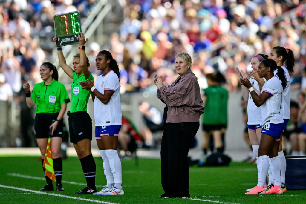 USWNT head coach Emma Hayes watches player substitutions during a match.