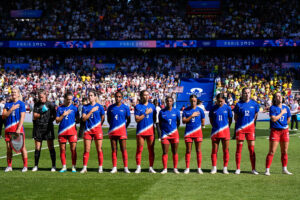 The USWNT listens to the national anthem before the 2024 Olympics gold-medal match