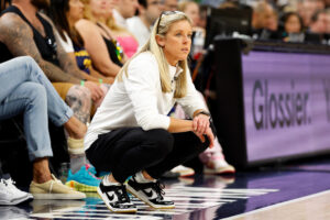 Former Indiana Fever head coach Christie Sides squats down during a game