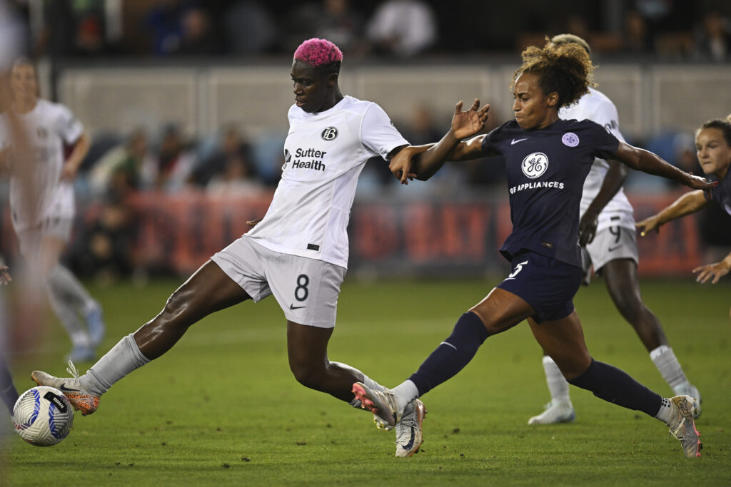 Bay's Asisat Oshoala dribbles past Louisville's Ellie Jean during an NWSL match.