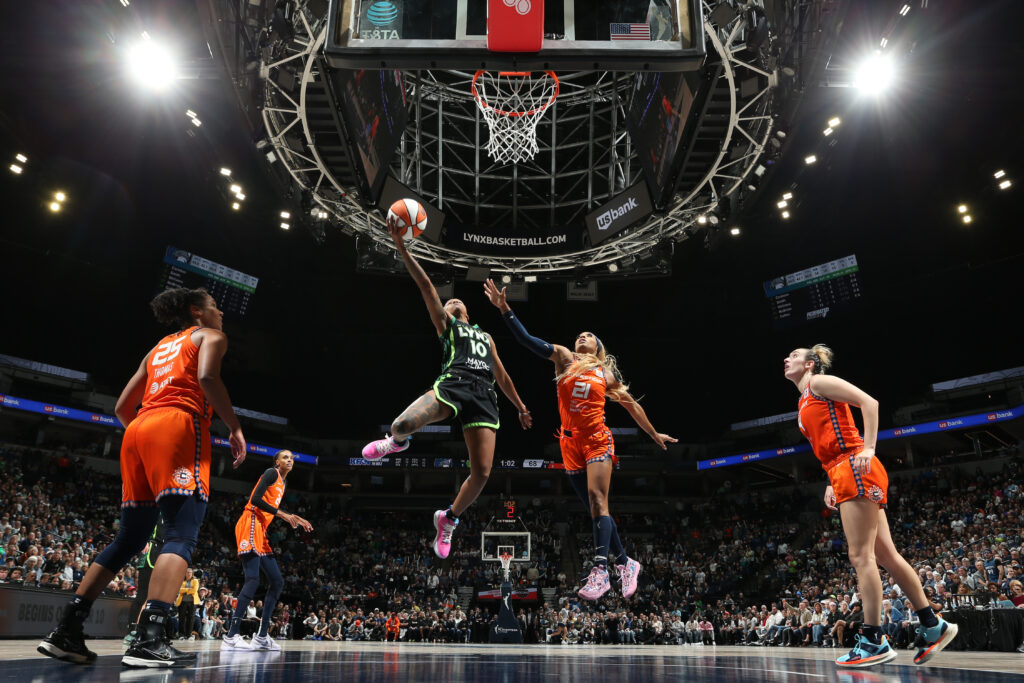 Lynx guard Courtney Williams lays up a shot surrounded by Connecticut defenders.