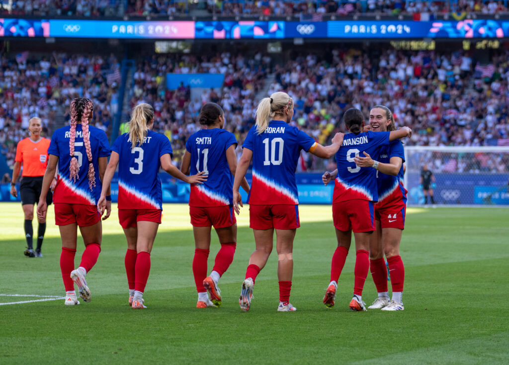 USWNT players walk on the pitch during the 2024 Olympics