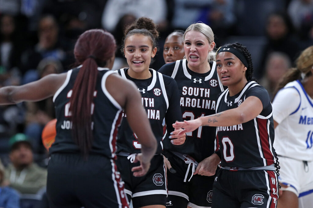 South Carolina players chat during a 2024 preseason women's college basketball game.