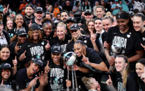 The New York Liberty pose with their first-ever WNBA championship trophy.