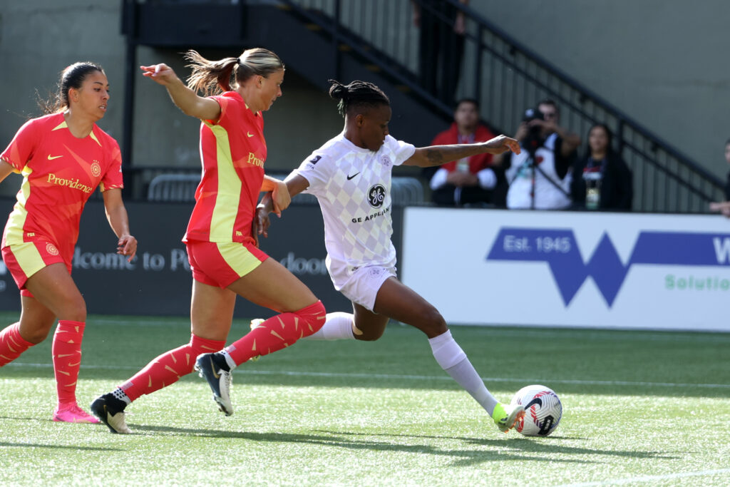 Louisville forward Uchenna Kanu beats Portland's Kelli Hubly for a goal in an NWSL game.