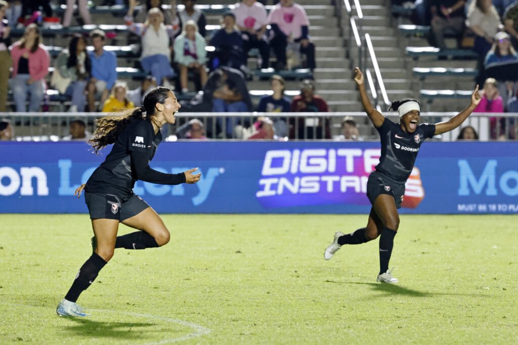 Angel City FC forward Christen Press celebrates with defender Jasmyne Spencer after scoring a goal against the North Carolina Courage in an NWSL game.