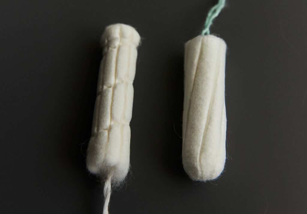 Two tampons sit side-by-side with the Sequel tampon showing a spiral design.