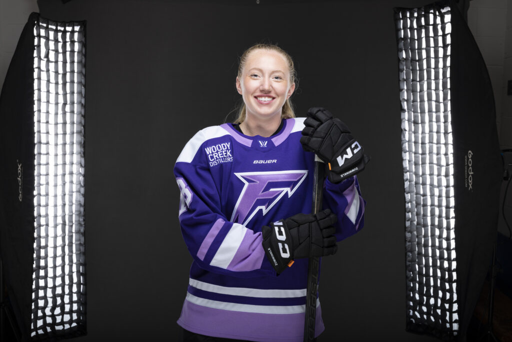 Minnesota Frost player models new purple PWHL jersey.