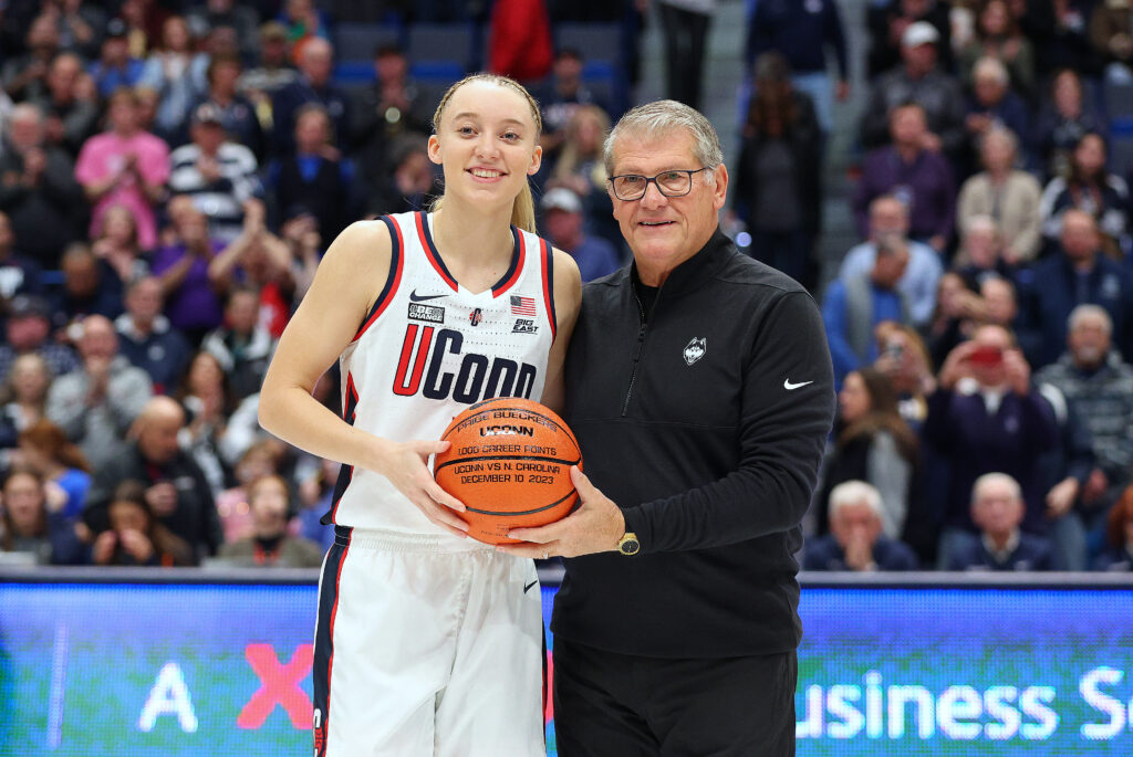 At her 1,000-point celebration, UConn guard Paige Bueckers poses with coach Geno Auriemma.