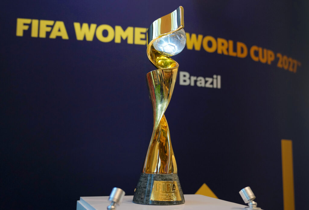 The 2027 World Cup trophy sits on a pedestal before a sign announcing Brazil as the host nation.