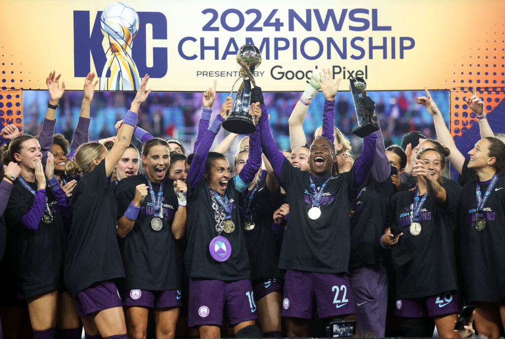 The Orlando Pride lift their trophy after winning the 2024 NWSL Championship.