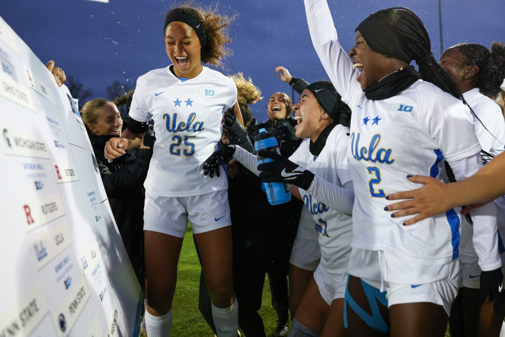 Defenders Nicki Fraser and Ayo Oke celebrate UCLA's NCAA college soccer Big Ten tournament quarterfinal win.