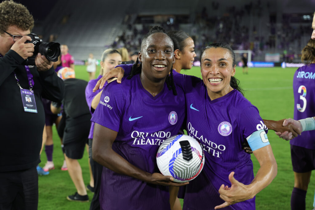 Orlando teammates and NWSL MVP award finalists Barbra Banda and Marta pose with the game ball after a win.