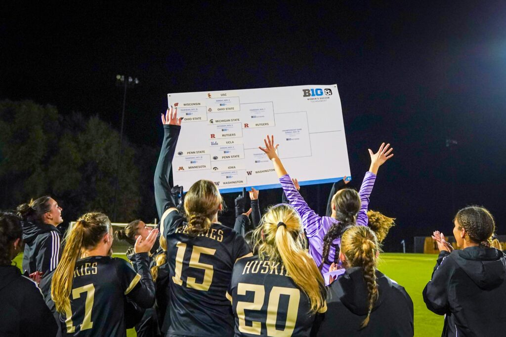 The unranked Washington Huskies celebrate their Big Ten tournament quarterfinal upset win over No. 17 Iowa.