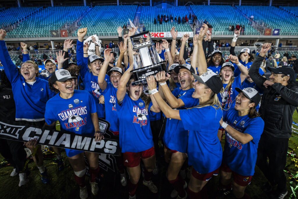 Kansas college soccer team lifts the 2024 Big 12 tournament trophy.