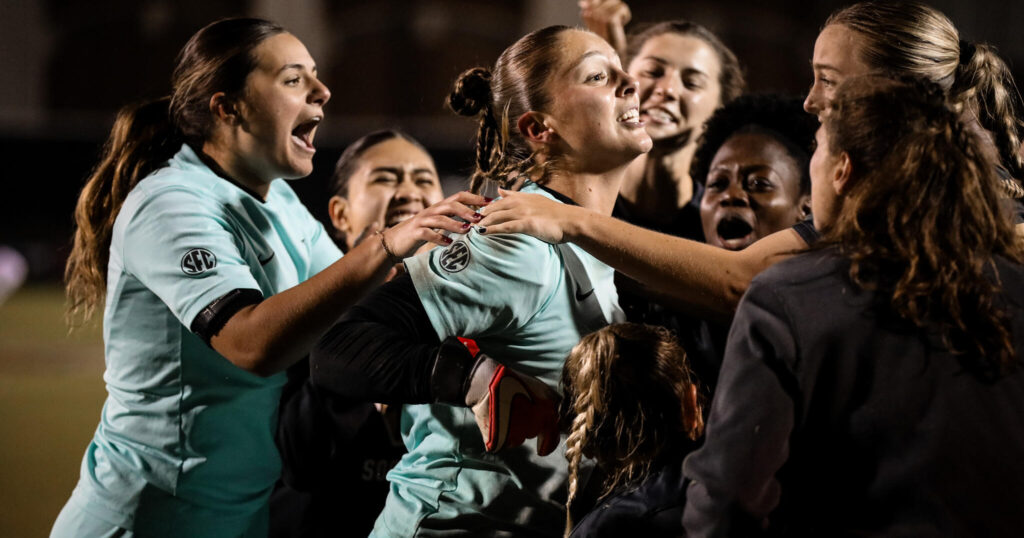 No. 8 Vanderbilt players mob goalkeeper Sara Wojdelko after her penalty saves clinched Friday's upset win over No. 1 Florida State in the NCAA soccer championship tournament.