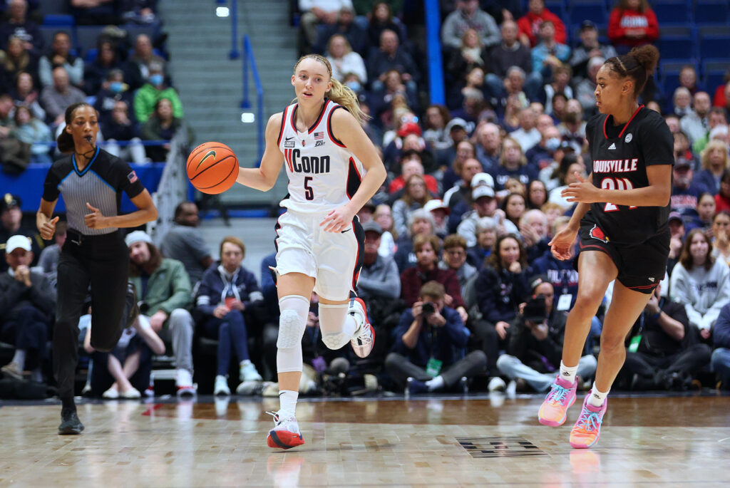 UConn's Paige Bueckers dribbles past Louisville's Eylia Love in a 2023 women's college basketball game.