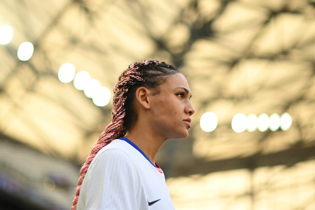 A close-up profile of USWNT star Trinity Rodman looking out on the 2024 Olympic pitch.