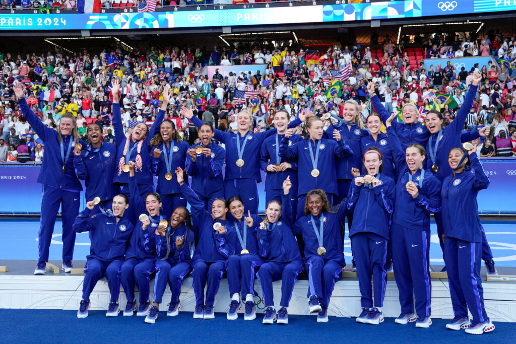 The USWNT celebrates their gold medal on the 2024 Olympic podium.