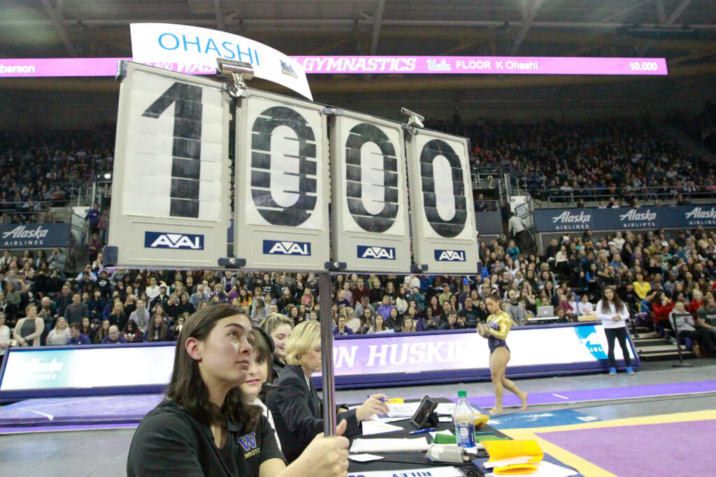 A perfect 10.00 score is raised by a judge at an NCAA gymnastics meet.