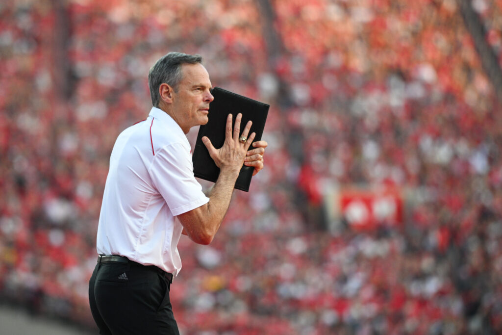 Nebraska volleyball coach John Cook signals to a player during the team's international record-breaking football stadium match.