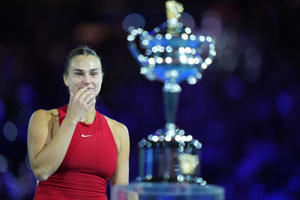 Aryna Sabalenka looks at the Australian Open trophy after she won the 2024 Grand Slam.