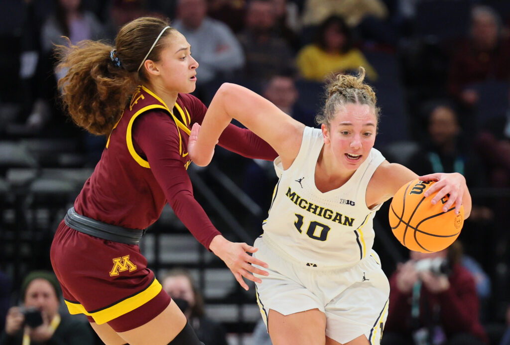 Michigan's Jordan Hobbs dribbles around Minnesota's Amaya Battle during a 2024 NCAA basketball game.