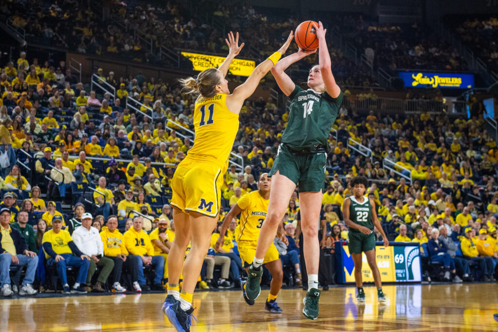 Michigan's Greta Kampschroeder guards a shot from Michigan State's Grace VanSlooten in Saturday's NCAA basketball game.