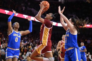 USC's JuJu Watkins drives to the basket between UCLA's Janiah Barker and Elina Aarnisalo.