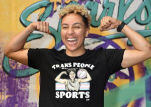 Layshia Clarendon wears a T-shirt with an image of themselves that reads "Trans People Belong in Sports" before a 2024 LA Sparks game.