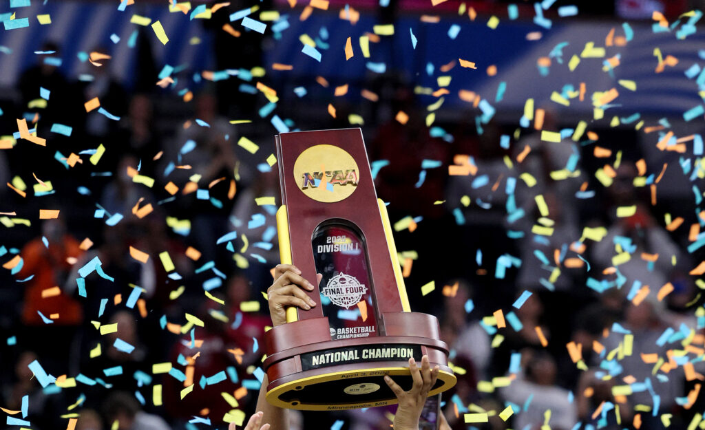 The NCAA Division I basketball championship trophy is raised under a shower of confetti at the 2022 Final Four.