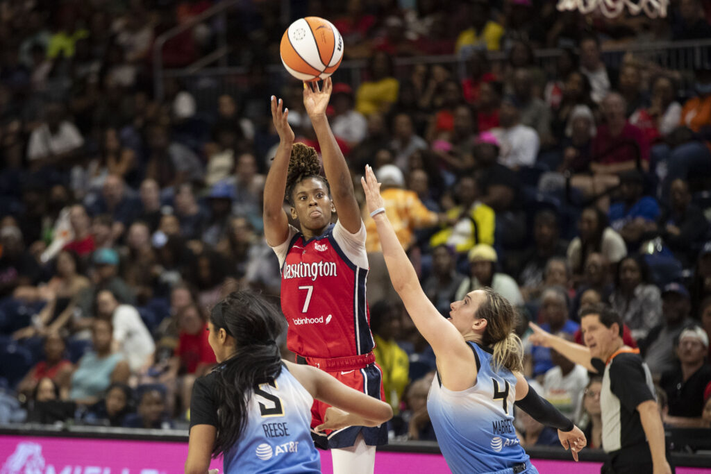 Washington guard Ariel Atkins shoots the ball over Chicago Sky defenders during a 2024 WNBA game.