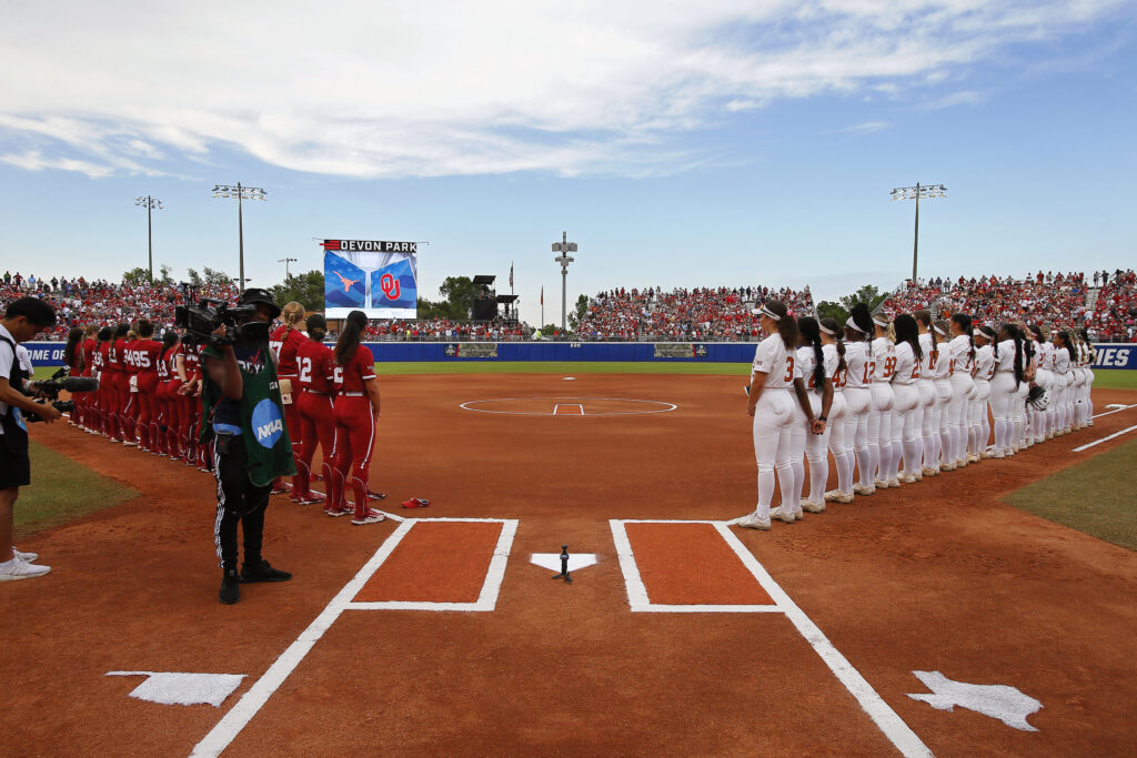 Oklahoma and Texas line up on the softball field before the second game of the 2024 Women's College World Series.