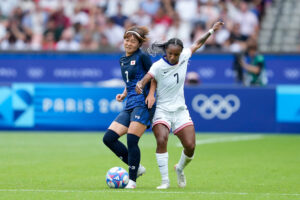 USWNT star Crystal Dunn battles Japan's Miyazawa Hinata for the ball during their 2024 Olympics quarterfinal.