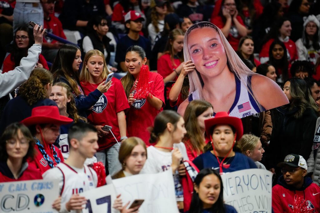 UConn fans hold up a cut-out of star Paige Bueckers before a November 2024 basketball game.