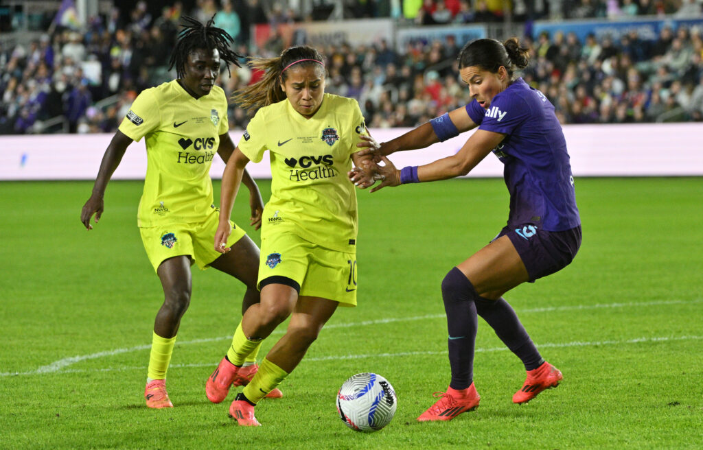 International Washington Spirit stars Rosemonde Kouassi and Leicy Santos battle Orlando's Emily Sams for possession during the 2024 NWSL Championship.