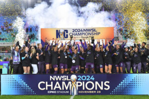 The Orlando Pride lifts their 2024 NWSL Championship trophy as confetti flies during the post-match ceremony.