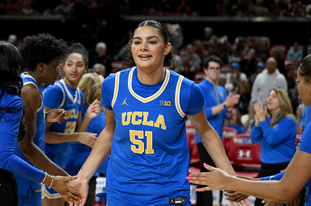 UCLA's Lauren Betts slaps her teammates hands as she enters the court for a Big Ten basketball game.