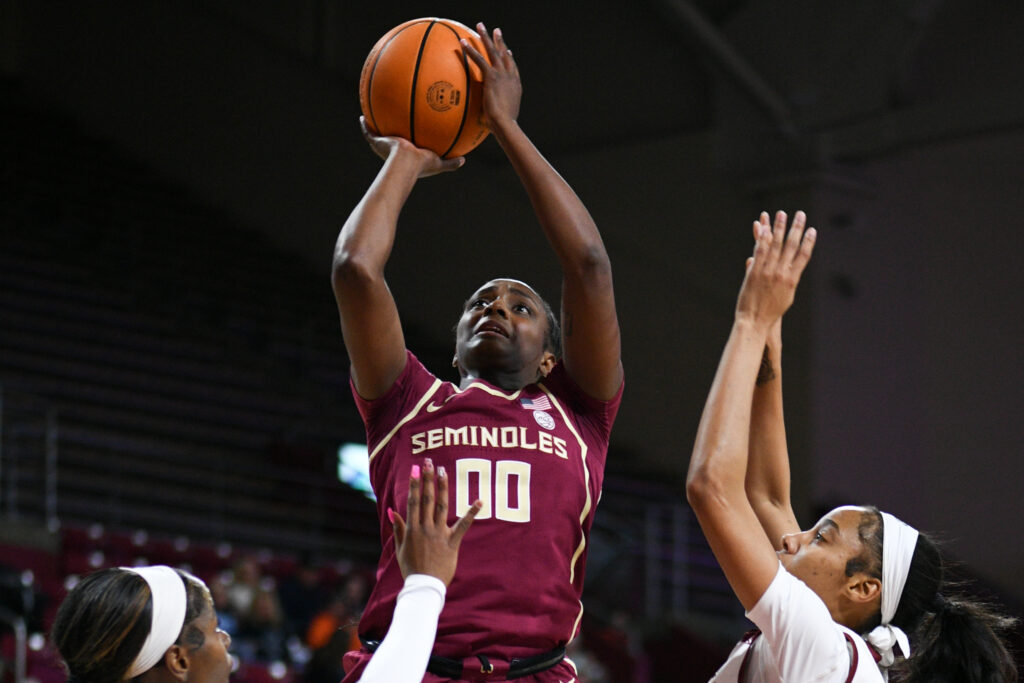 Florida State star Ta'Niya Latson shoots the ball over multiple defenders during a January 2025 game against Boston College.