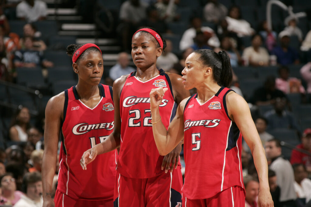 The Houston Comets' Roneeka Hodges, Sheryl Swoopes, and Dawn Staley discuss a play during a 2006 WNBA game.