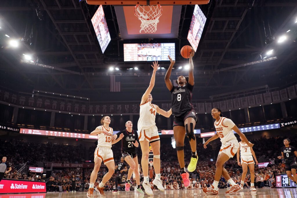 South Carolina's Joyce Edwards drives past Texas defenders to the basket during a 2025 SEC basketball game.