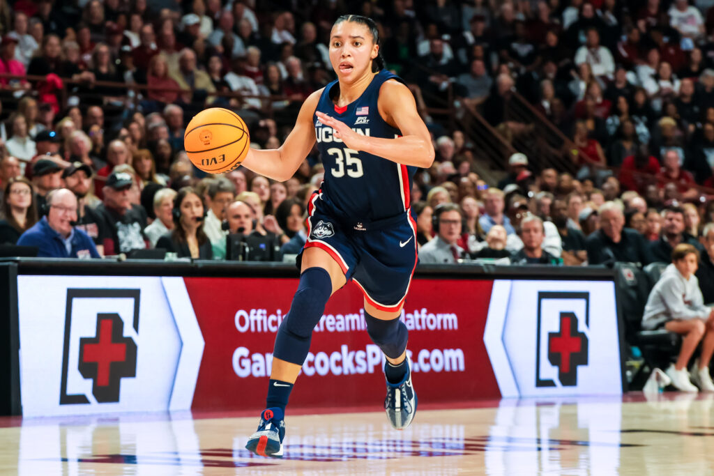 UConn basketball guard Azzi Fudd dribbles up the court against South Carolina.