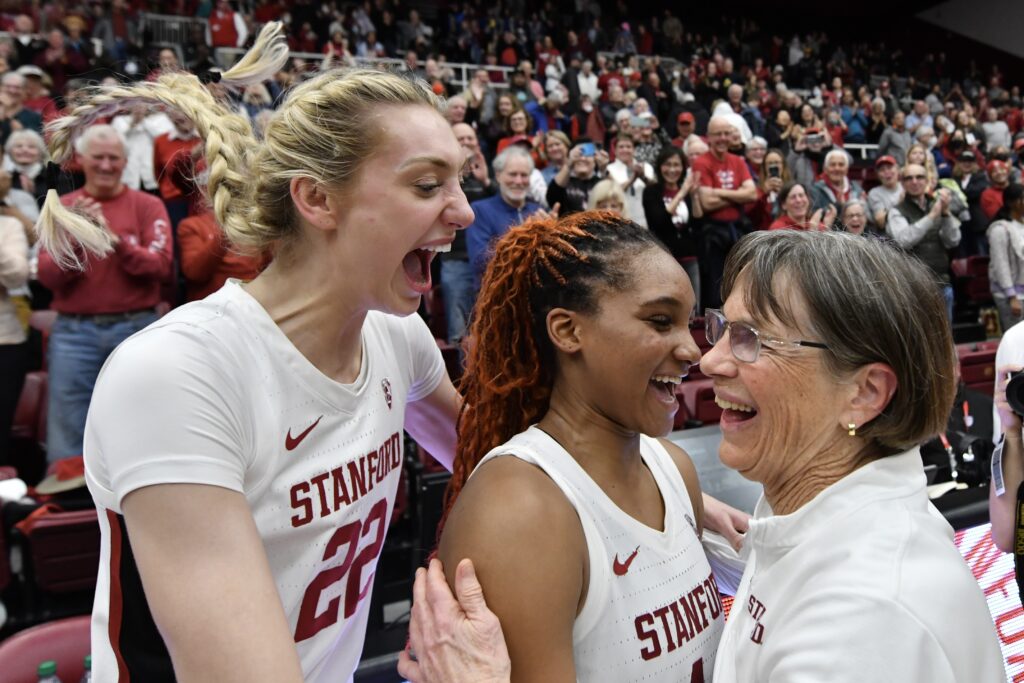 2023/24 Stanford basketball stars Cameron Brink and Kiki Iriafen celebrate a win with coach Tara VanDerveer