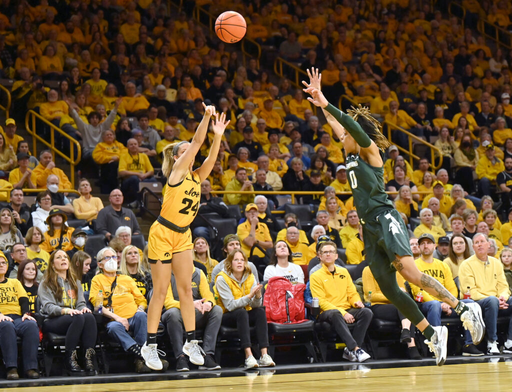 Iowa guard Gabby Marshall shoots over Michigan State's DeeDee Hagemann during a 2023/24 Big Ten basketball game.