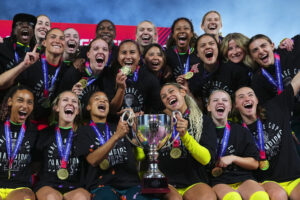 The Washington Spirit holds their 2025 NWSL Challenge Cup trophy after defeating the Orlando Pride.