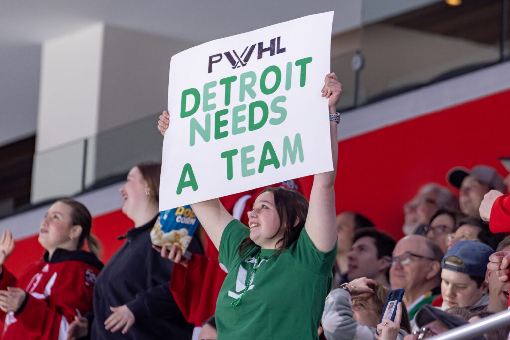 A PWHL fan holds up a sign that reads "Detroit needs a team" at Sunday's Takeover Tour game.